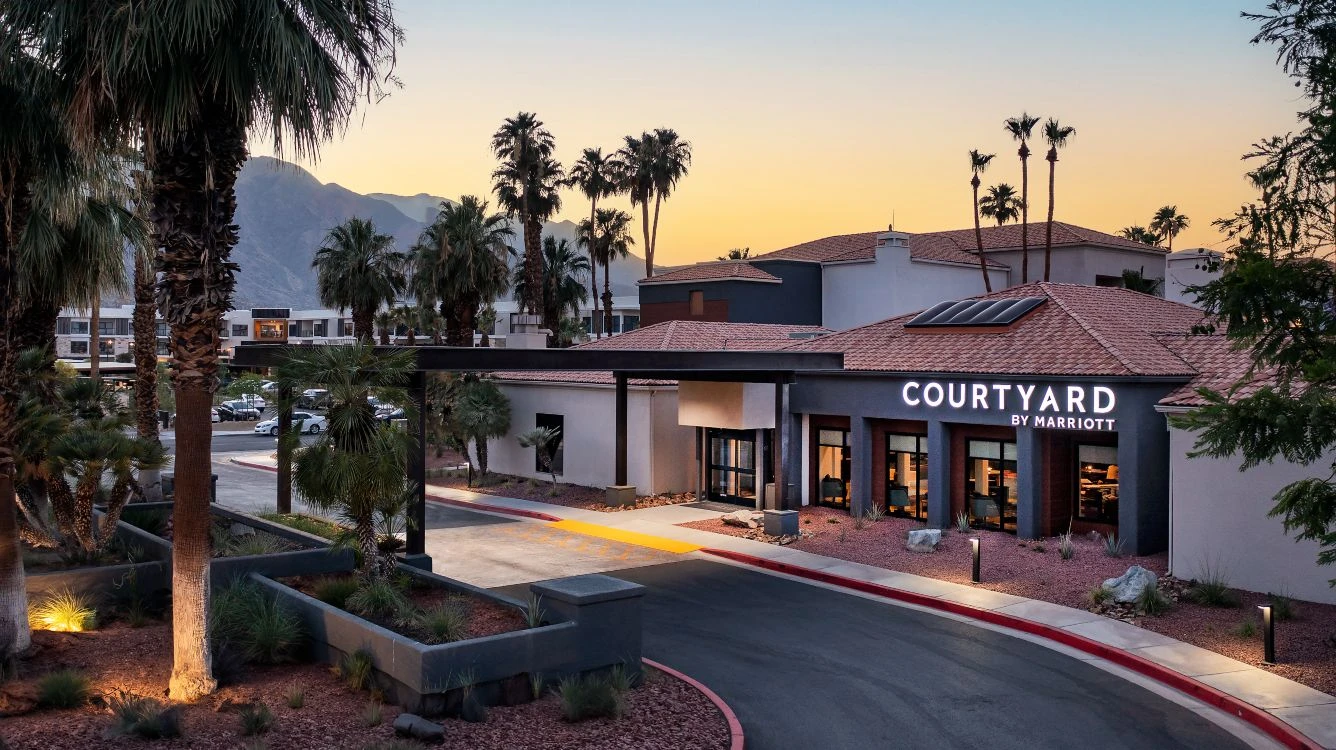exterior hotel renovation improves curb appeal of the courtyard by marriott hotel in palm springs california - a photo of the courtyard by marriott in palm springs CA with palm trees and a sunset